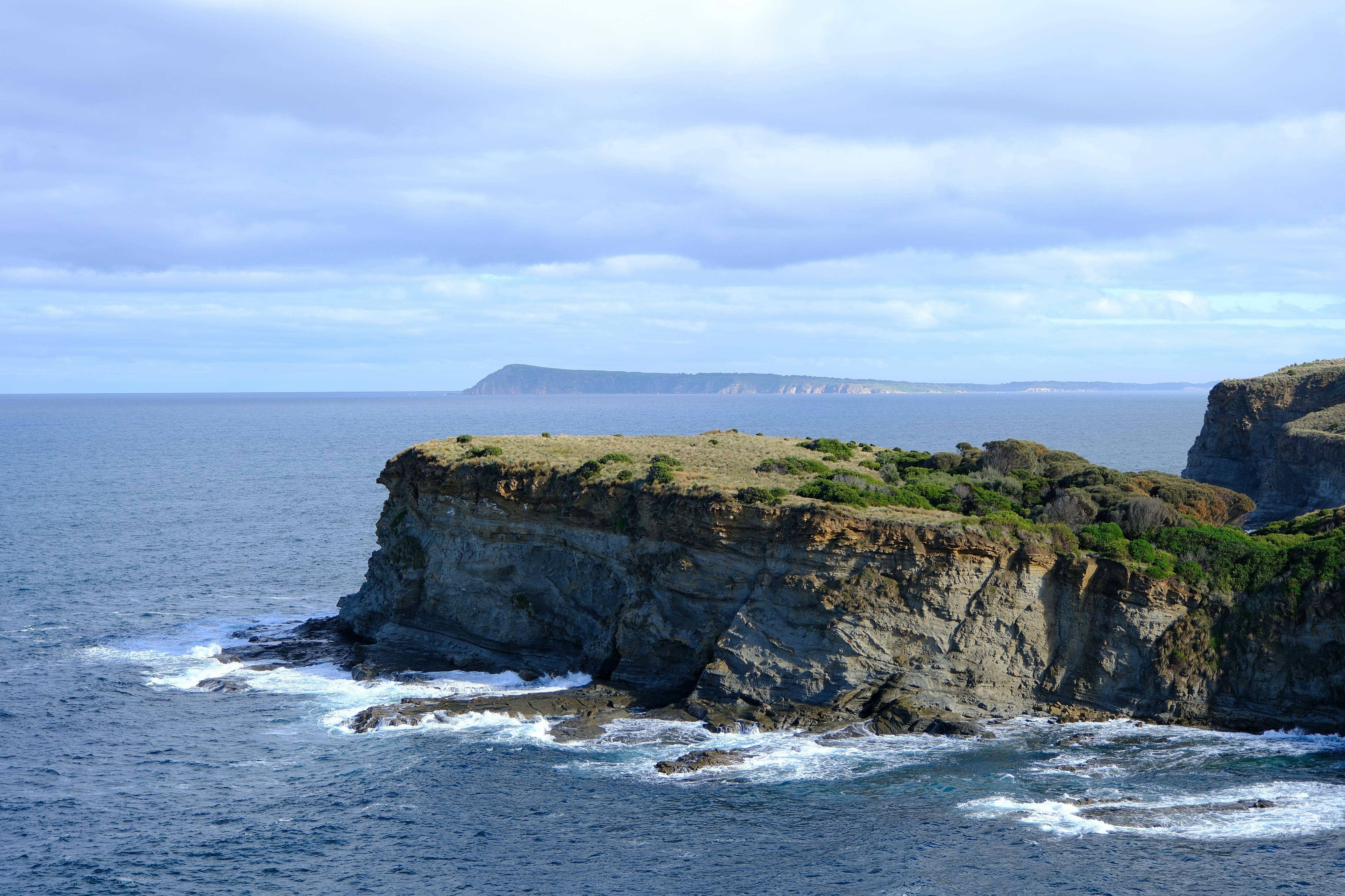 A large rock outcropping in the middle of the ocean