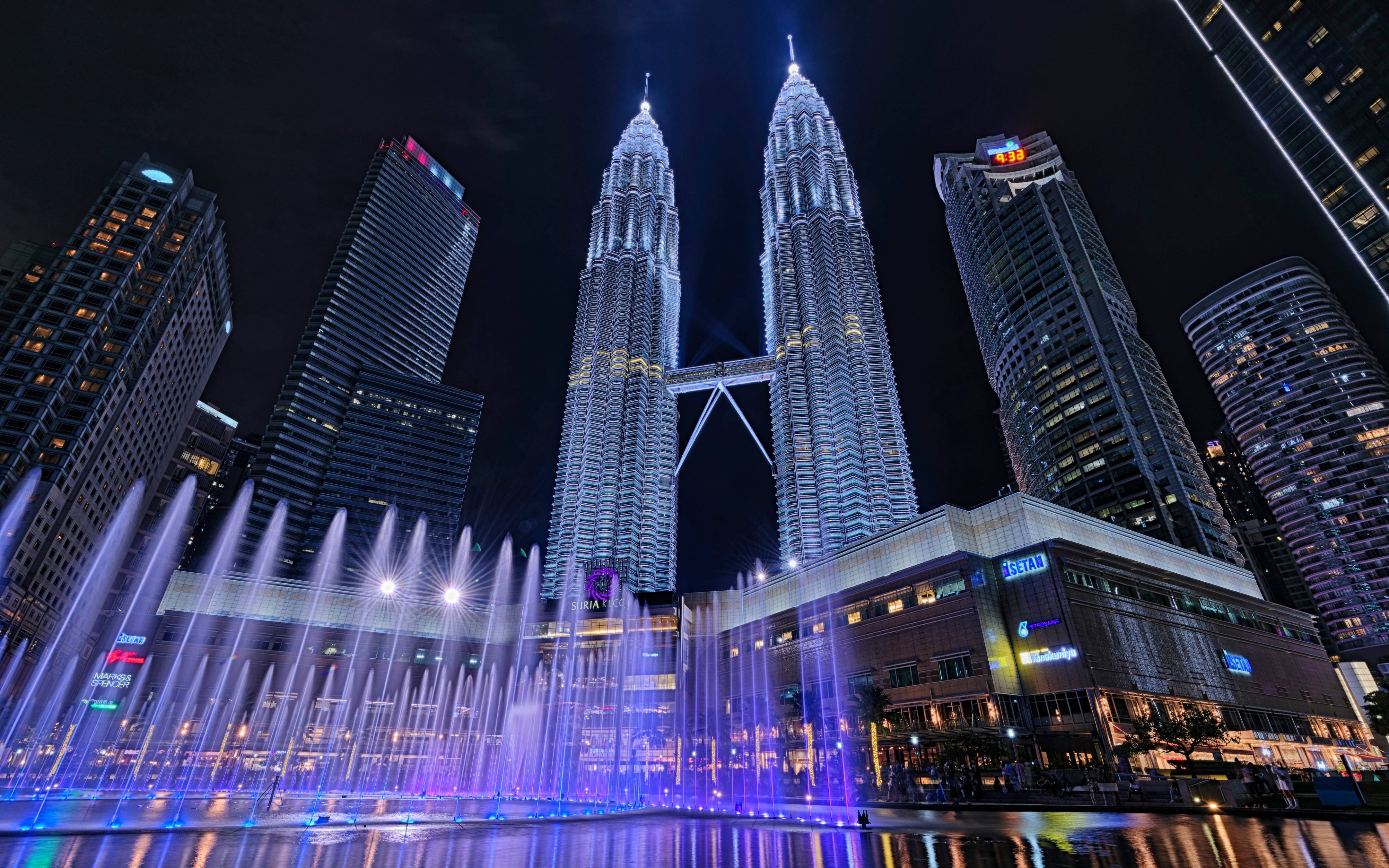 A large fountain in the middle of a city at night